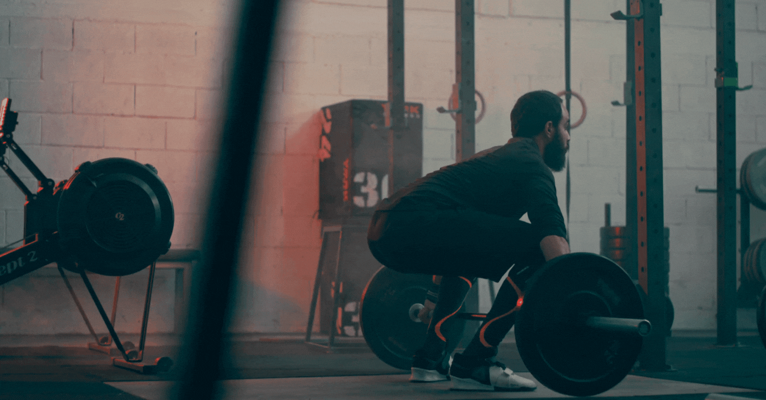 Man performing a barbell lift in a gym