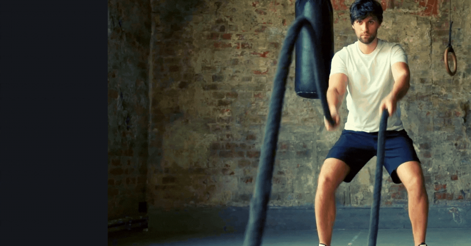 Man using battle ropes in a gym